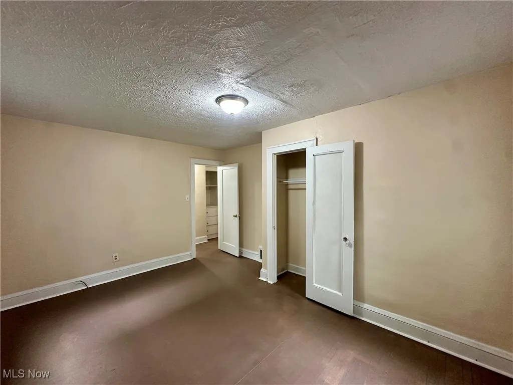 Unfurnished bedroom with baseboards, a closet, and a textured ceiling