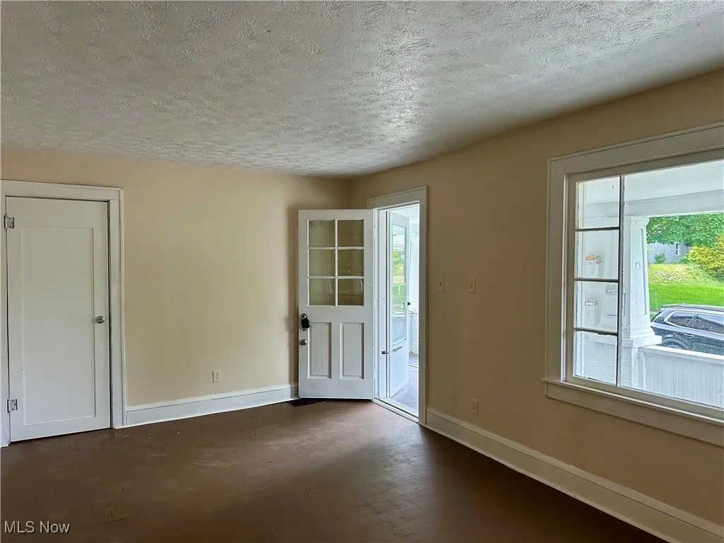 Entryway with a textured ceiling and baseboards