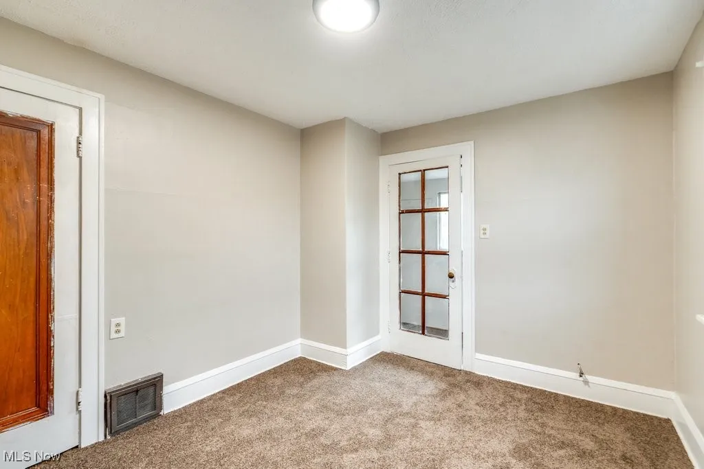 Carpeted spare room with baseboards