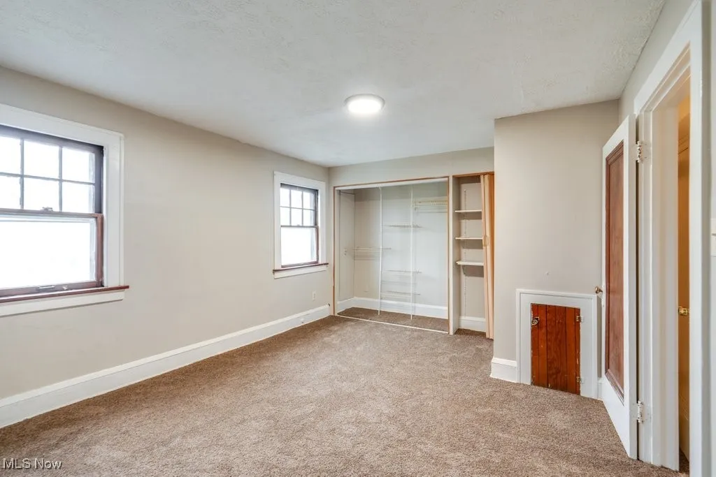Unfurnished bedroom with carpet, a closet, baseboards, and a textured ceiling