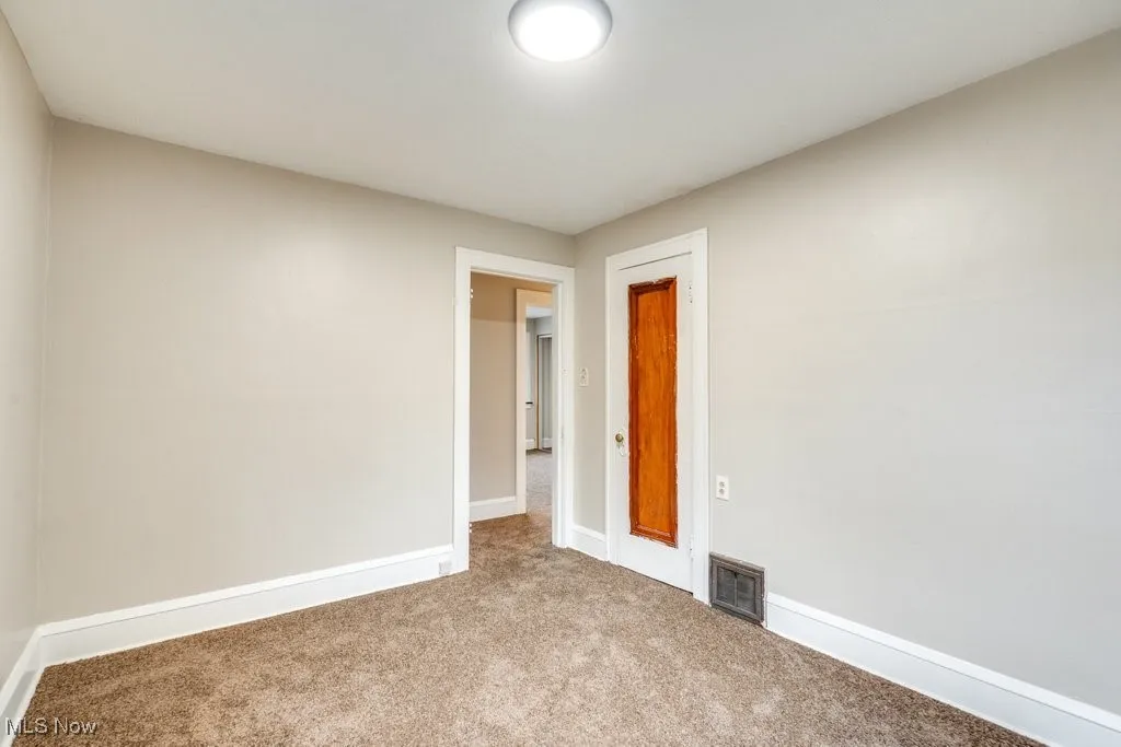 Carpeted spare room with baseboards
