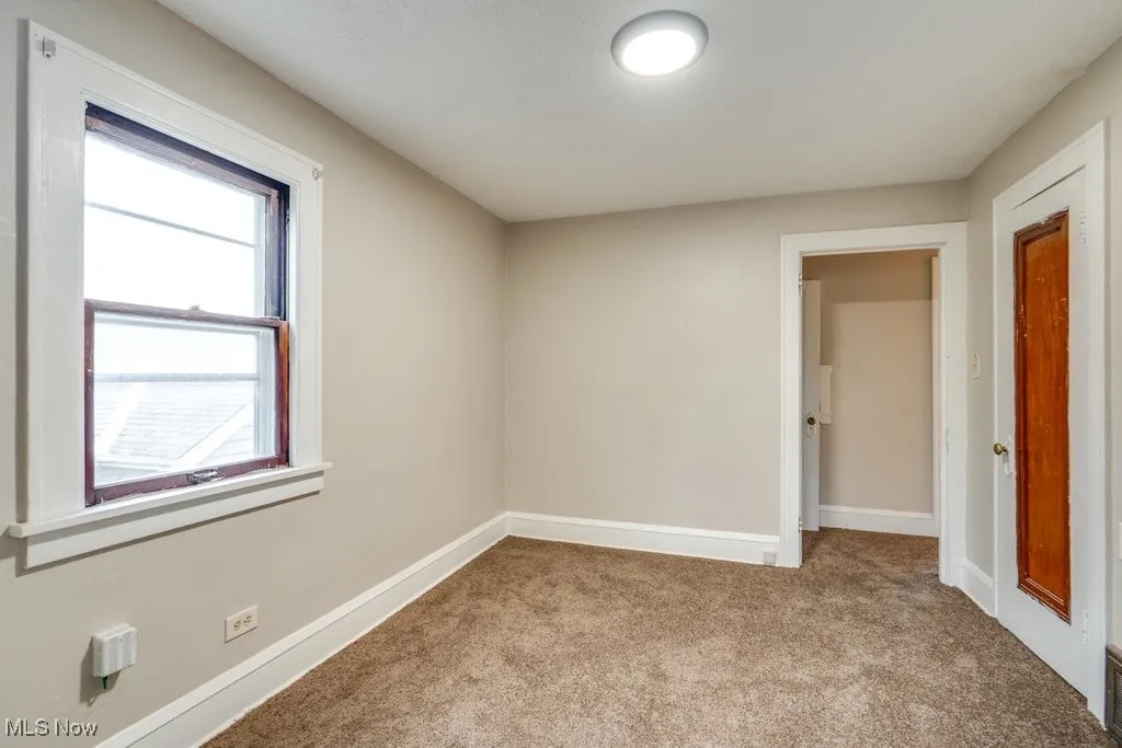 Unfurnished room with carpet floors and baseboards