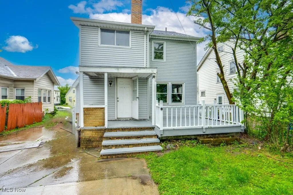 Back of house with a chimney and a deck