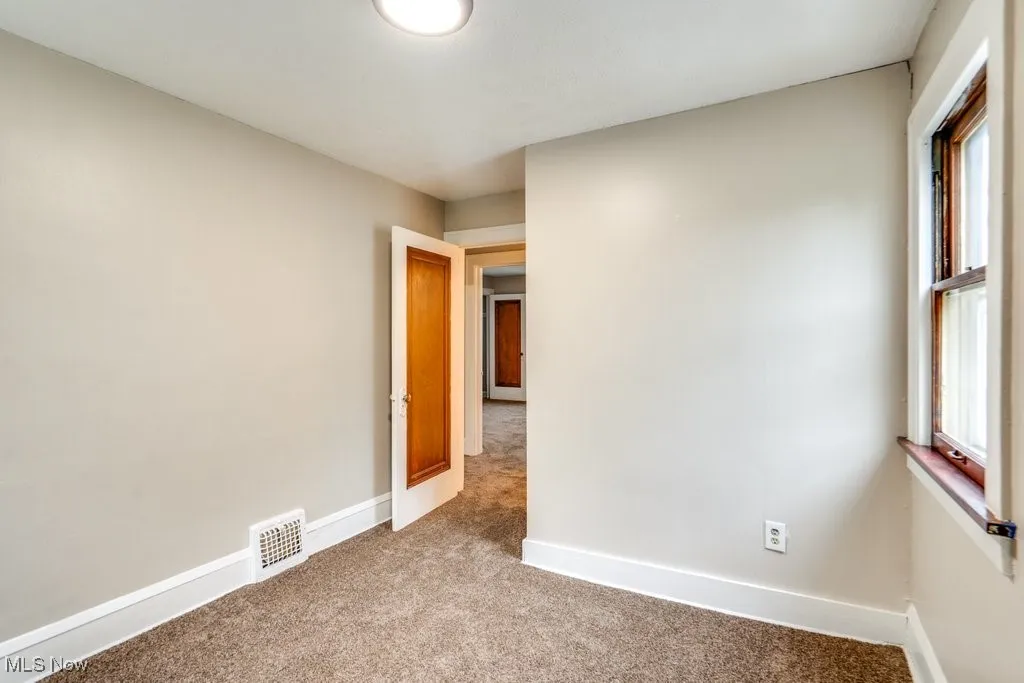 Unfurnished room with carpet flooring and baseboards