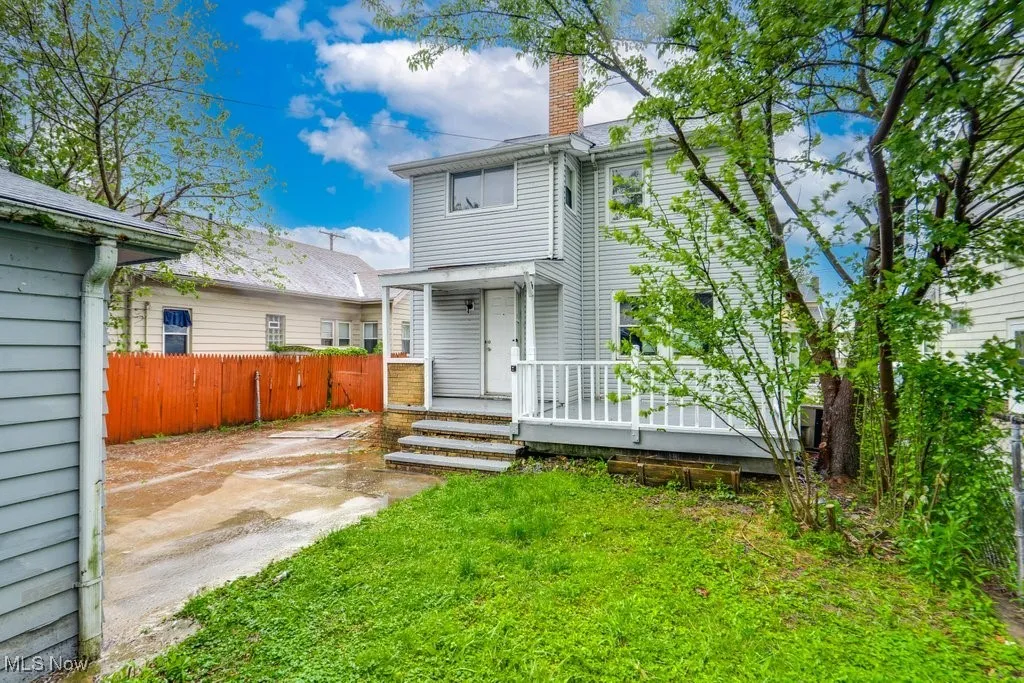 Back of property with covered porch and a chimney