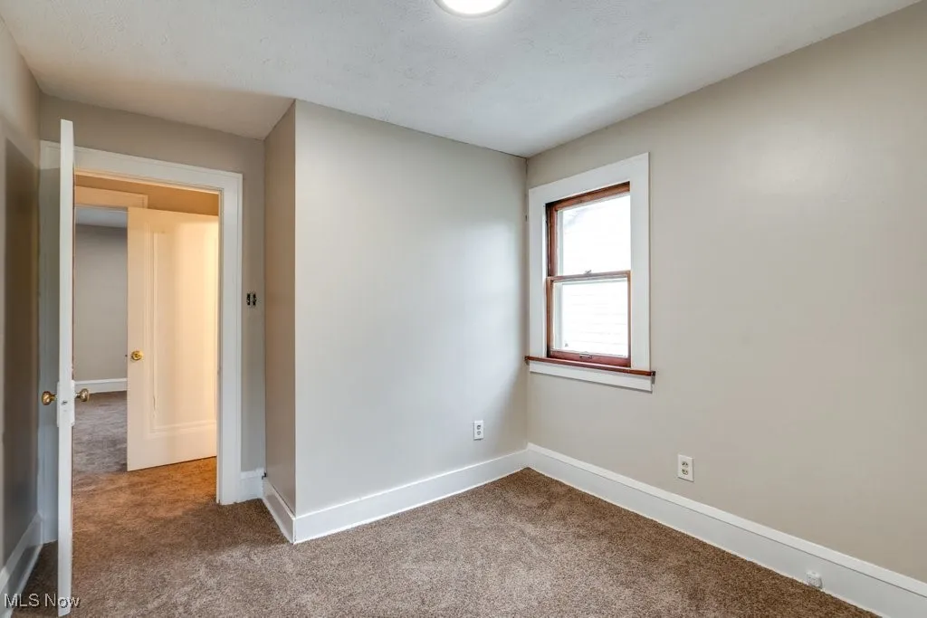 Carpeted spare room with baseboards