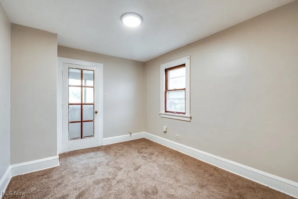 Carpeted empty room featuring baseboards