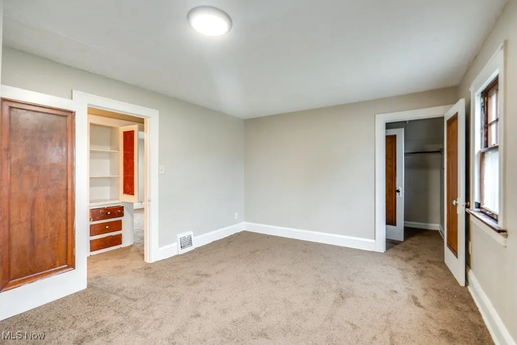 Unfurnished bedroom featuring carpet flooring, baseboards, a closet, and a spacious closet