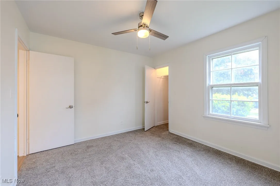 Unfurnished bedroom with carpet flooring, baseboards, and ceiling fan
