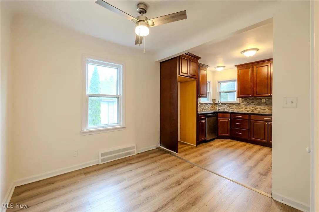 Kitchen featuring dishwasher, light wood-style floors, ceiling fan, and backsplash