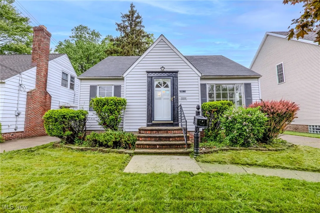 Bungalow-style home featuring a front yard and a shingled roof