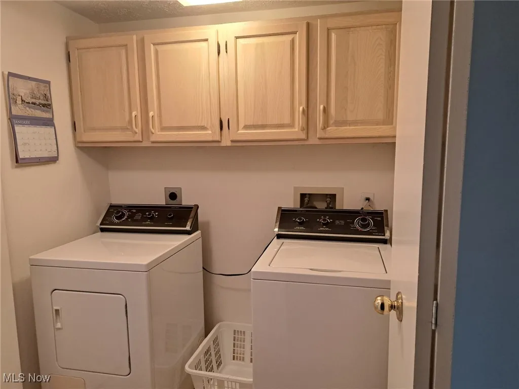 Laundry room featuring washer, dryer and cabinets