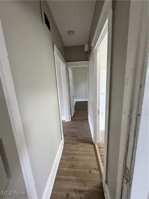 Corridor featuring wood finished floors and baseboards