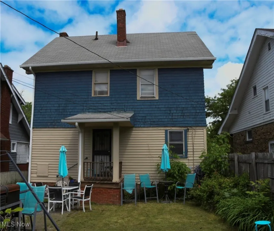 Rear view of property with a chimney and roof with shingles