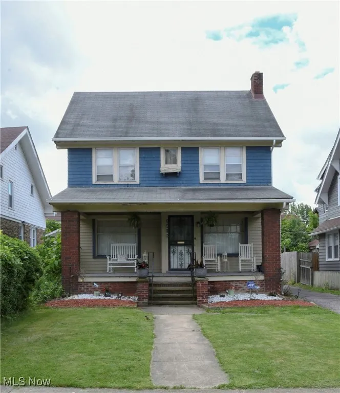 View of front facade with a chimney and covered porch