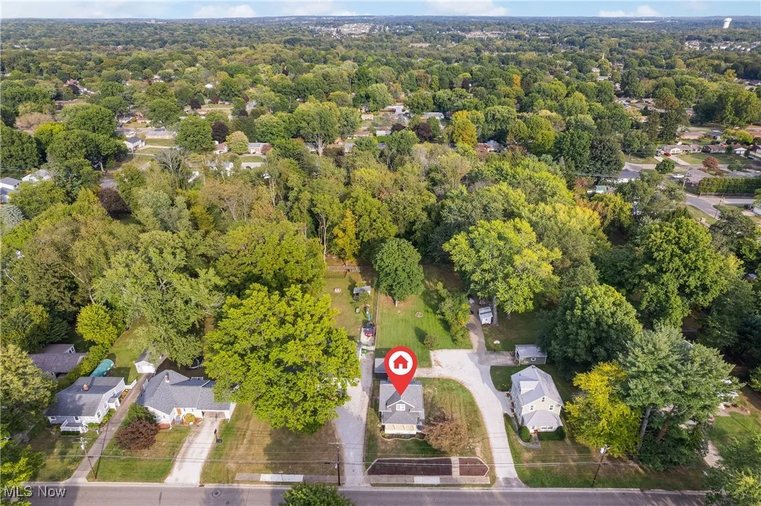 View of property location featuring a heavily wooded area and nearby suburban area