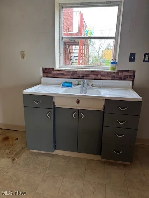 Bathroom featuring baseboards, tasteful backsplash, and vanity