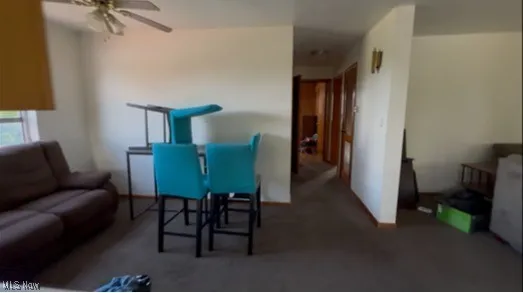 Dinig area with ceiling fan and carpet