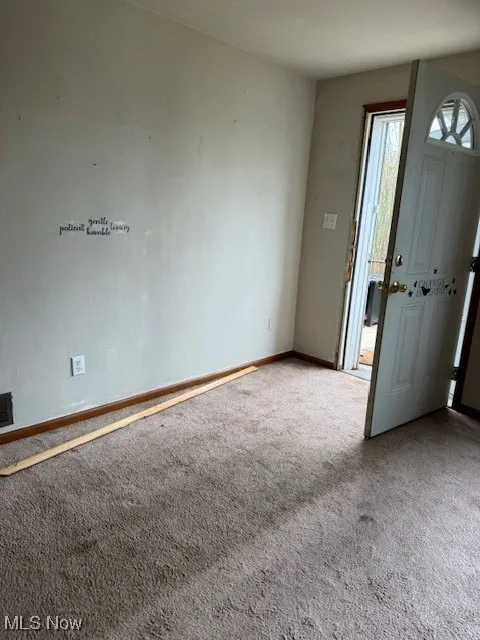 Carpeted entryway with baseboards