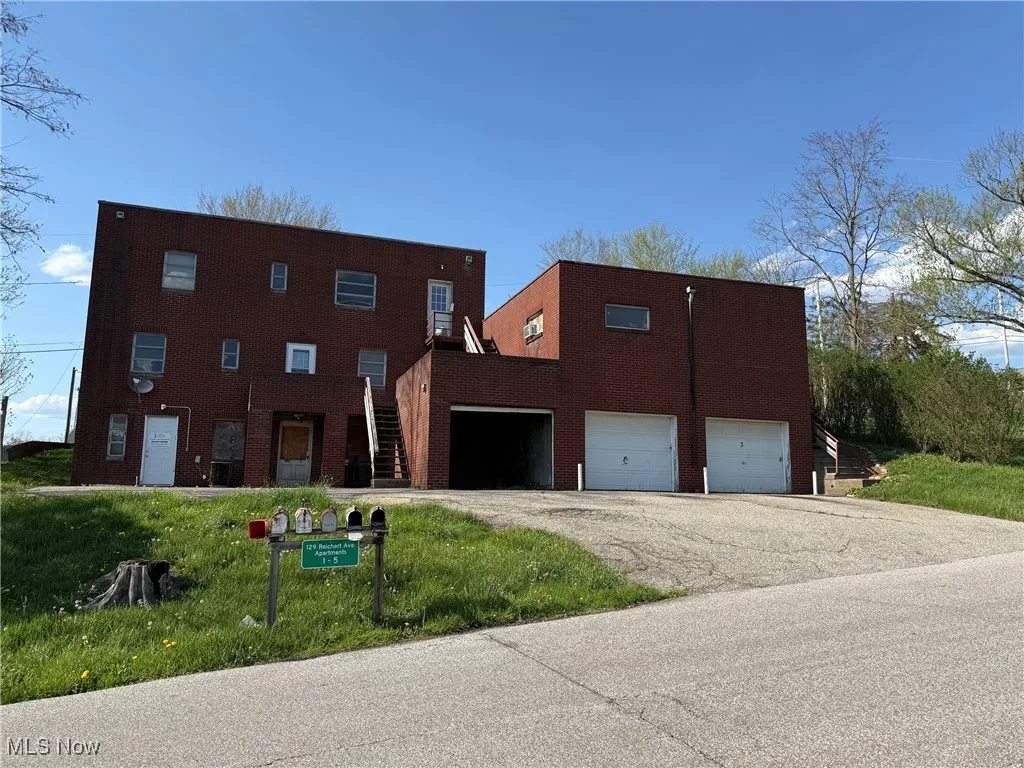 View of back of property featuring a garage and driveway
