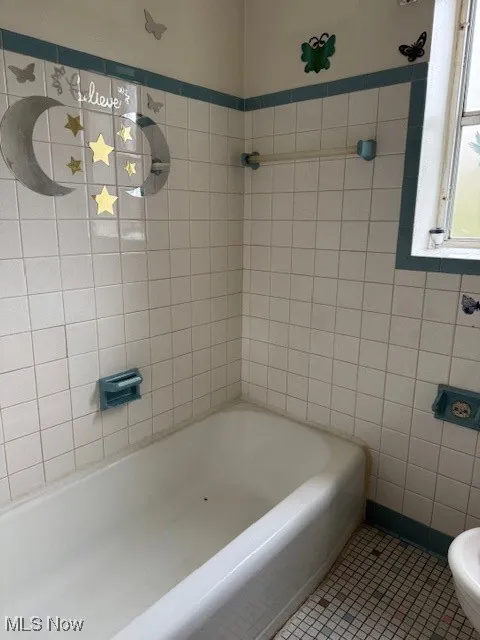 Bathroom with toilet and tile patterned flooring