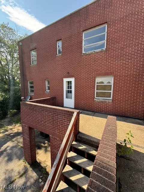 Rear view of house featuring brick siding
