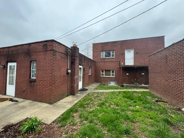 Side of house featuring brick siding