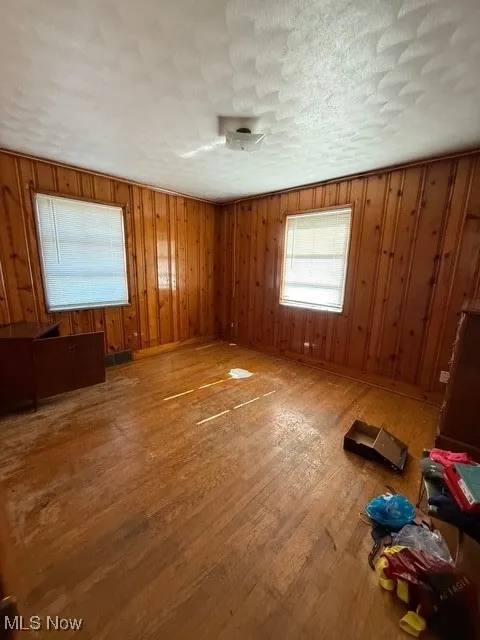 Empty bedroom with wood finished floors and wooden walls