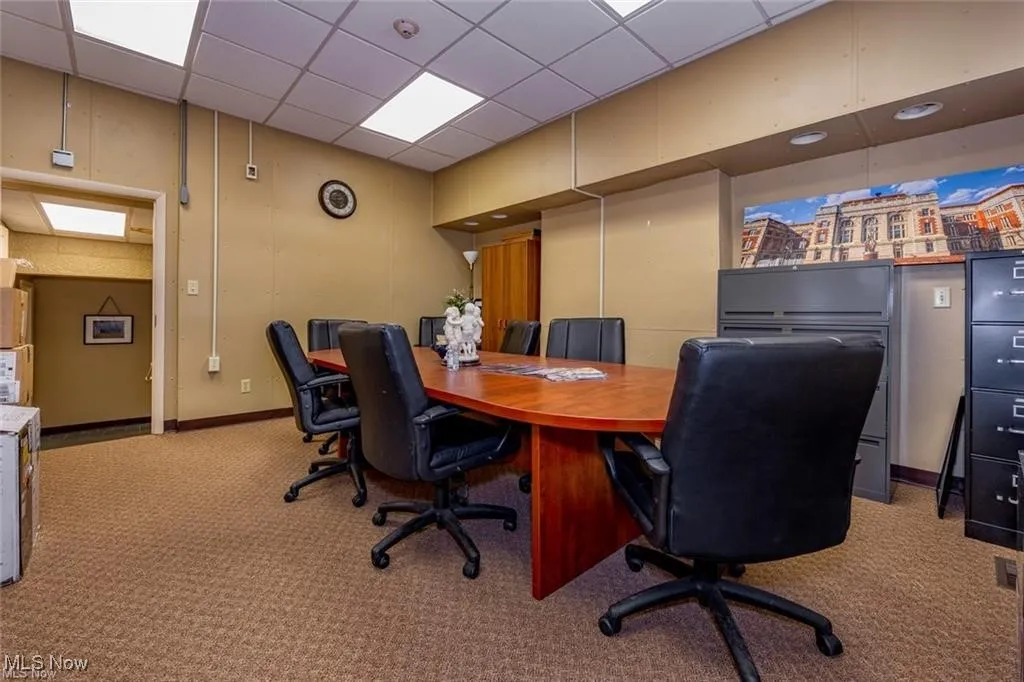 Carpeted home office featuring a drop ceiling