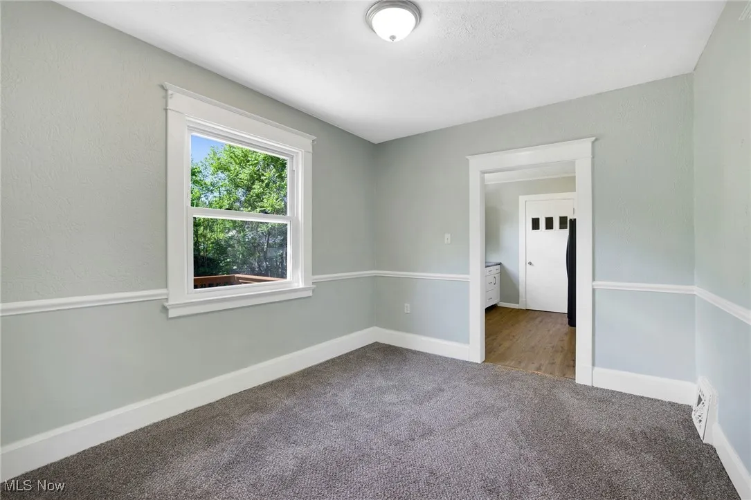 Unfurnished room with carpet and baseboards