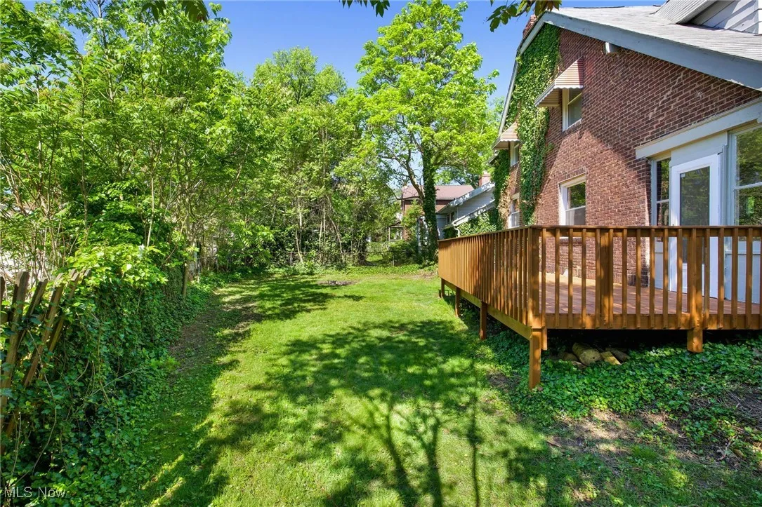 View of grassy yard with a wooden deck
