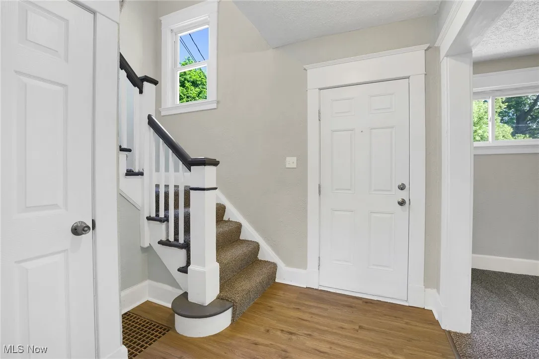 Entryway featuring healthy amount of natural light, baseboards, and stairway
