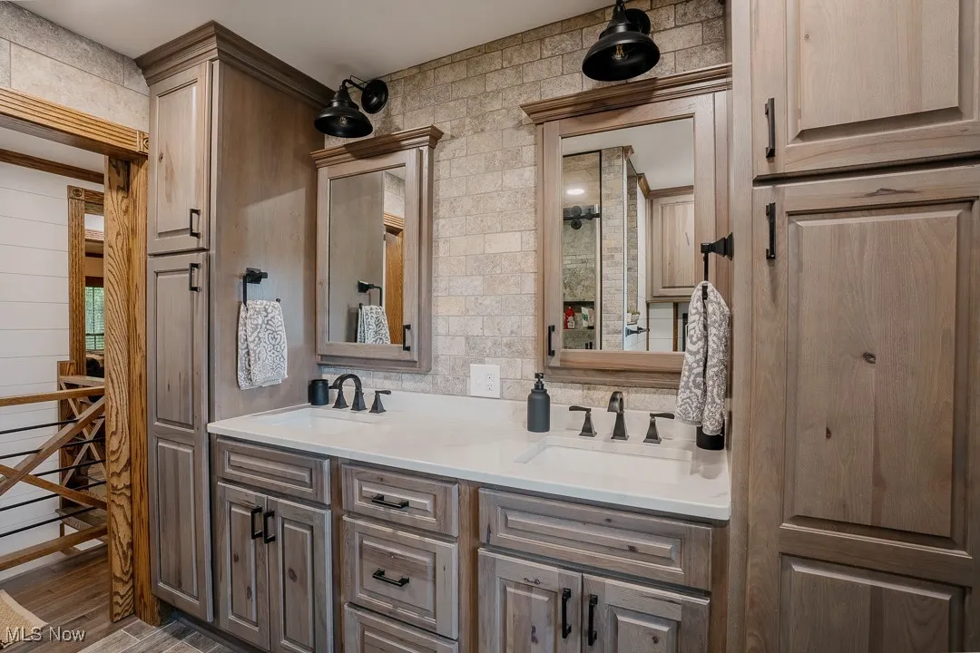 Bathroom with double vanity and wood finished floors