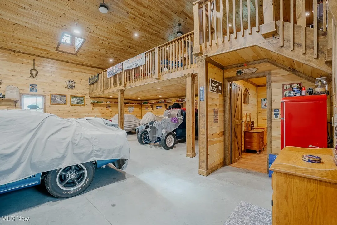 Bedroom featuring wooden walls, wooden ceiling, a high ceiling, and concrete floors