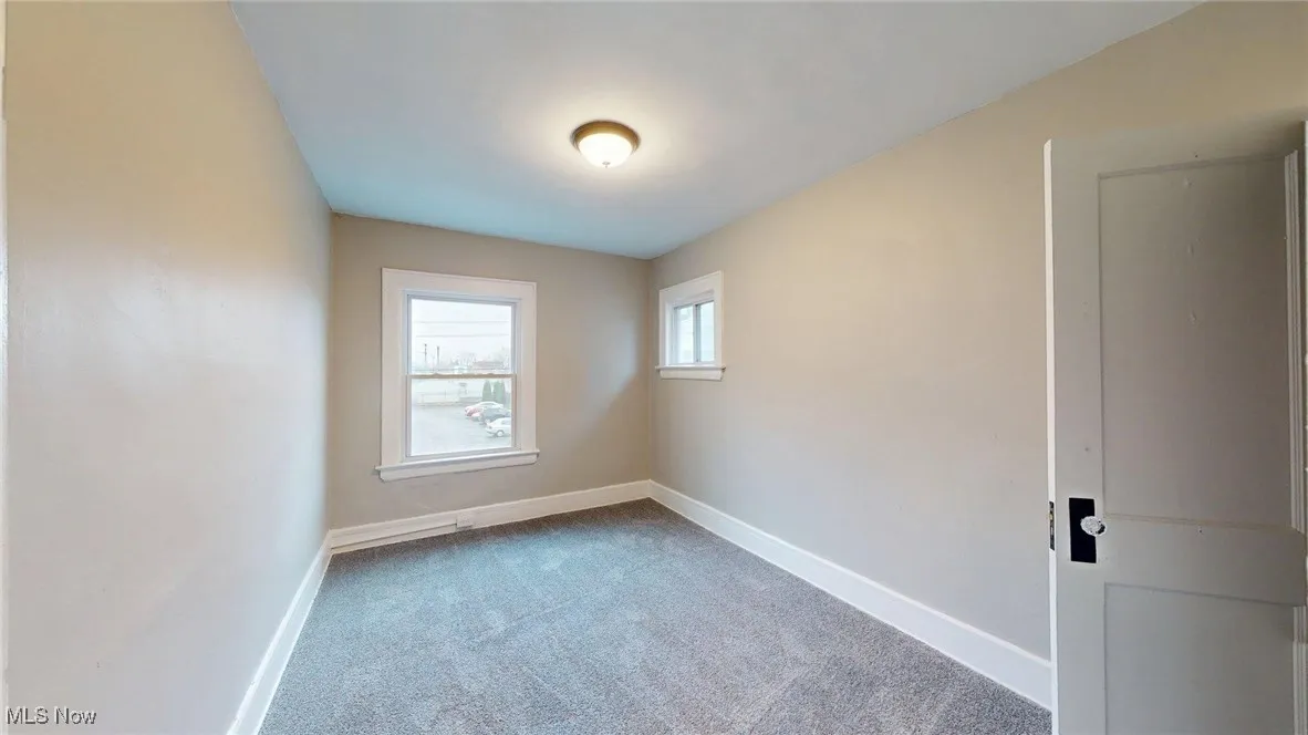 Carpeted spare room with baseboards