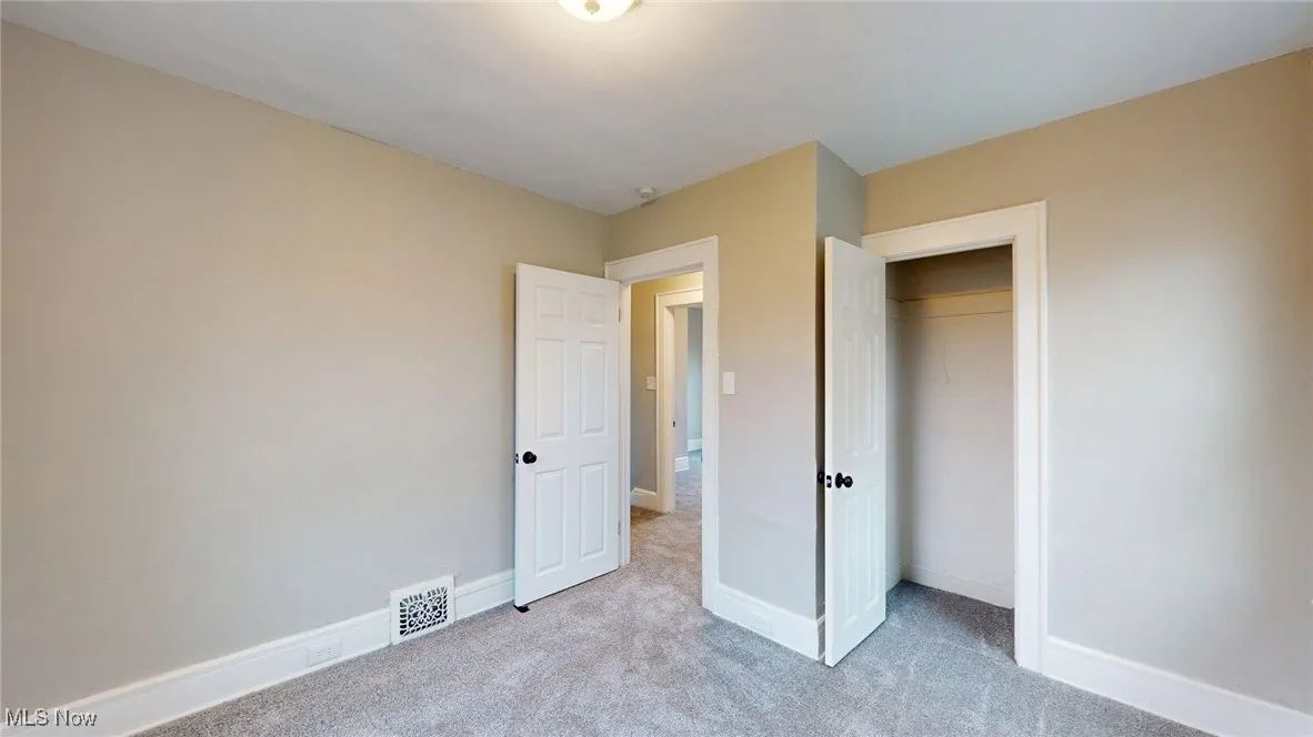 Unfurnished bedroom featuring visible vents, carpet flooring, and baseboards