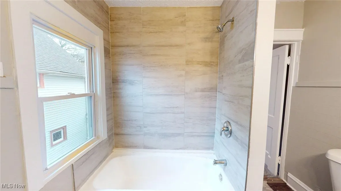 Bathroom featuring shower / bathtub combination and toilet