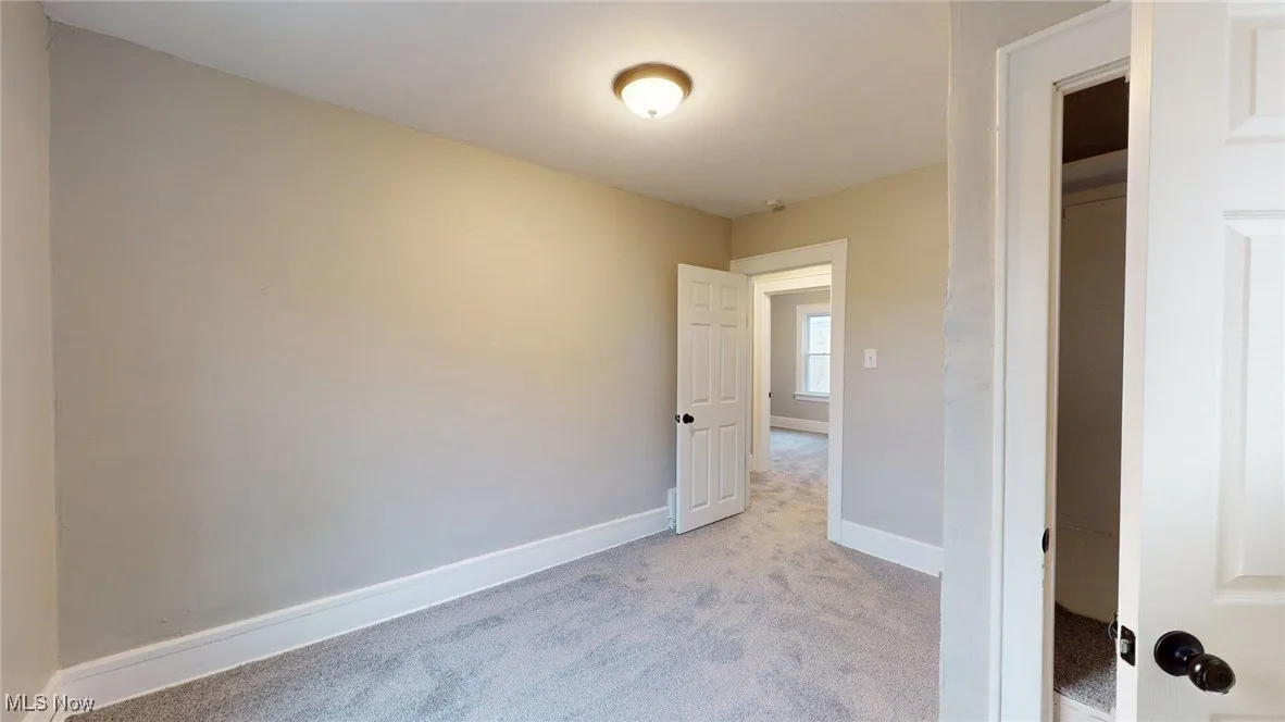Unfurnished room with light carpet and baseboards