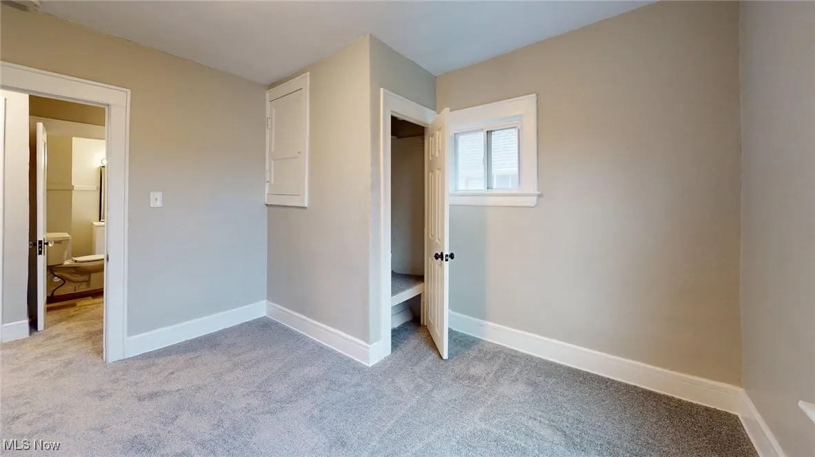 Unfurnished bedroom with baseboards and light colored carpet
