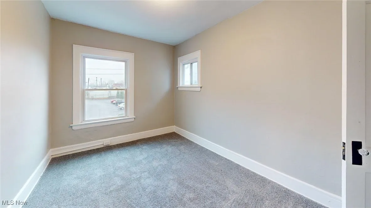 Empty room with carpet floors and baseboards