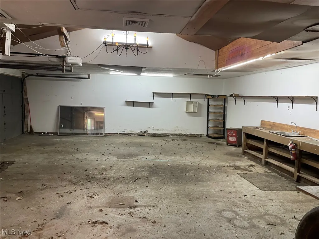 Garage featuring a workshop area and a garage door opener