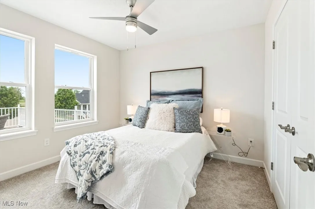 Bedroom with baseboards, carpet flooring, and a ceiling fan