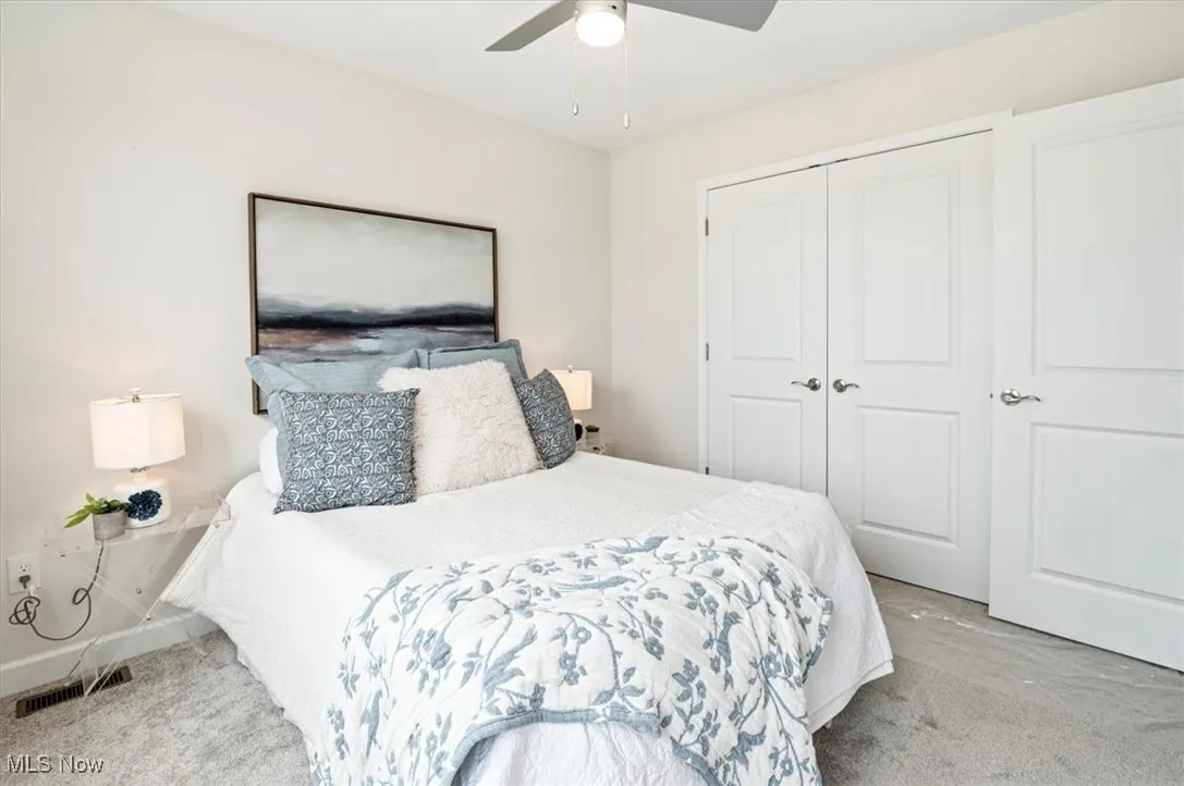 Carpeted bedroom featuring a closet and ceiling fan