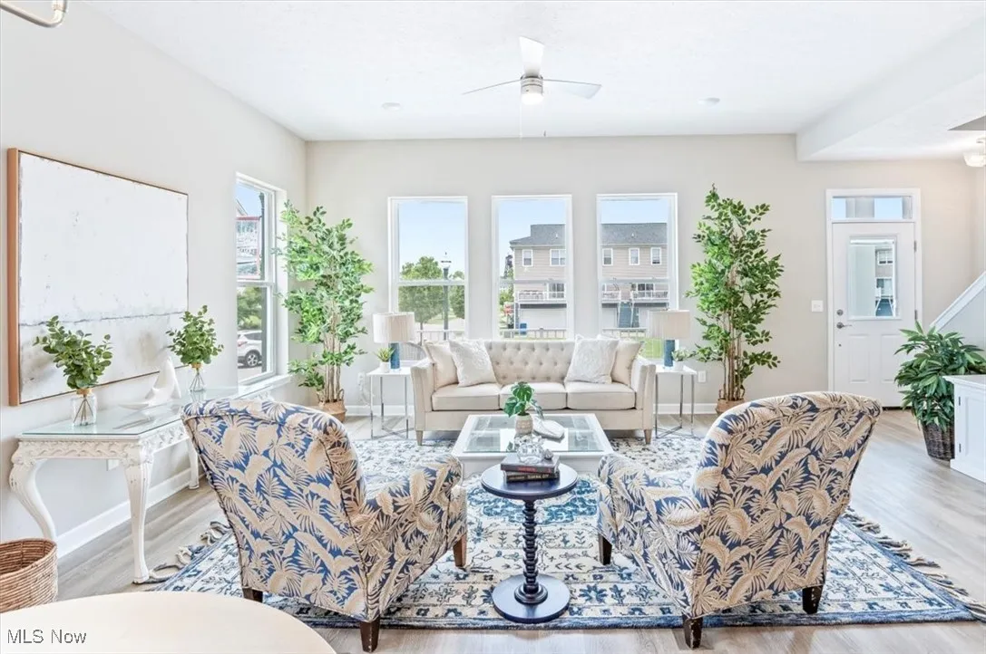 Living area with wood finished floors, a ceiling fan, and baseboards