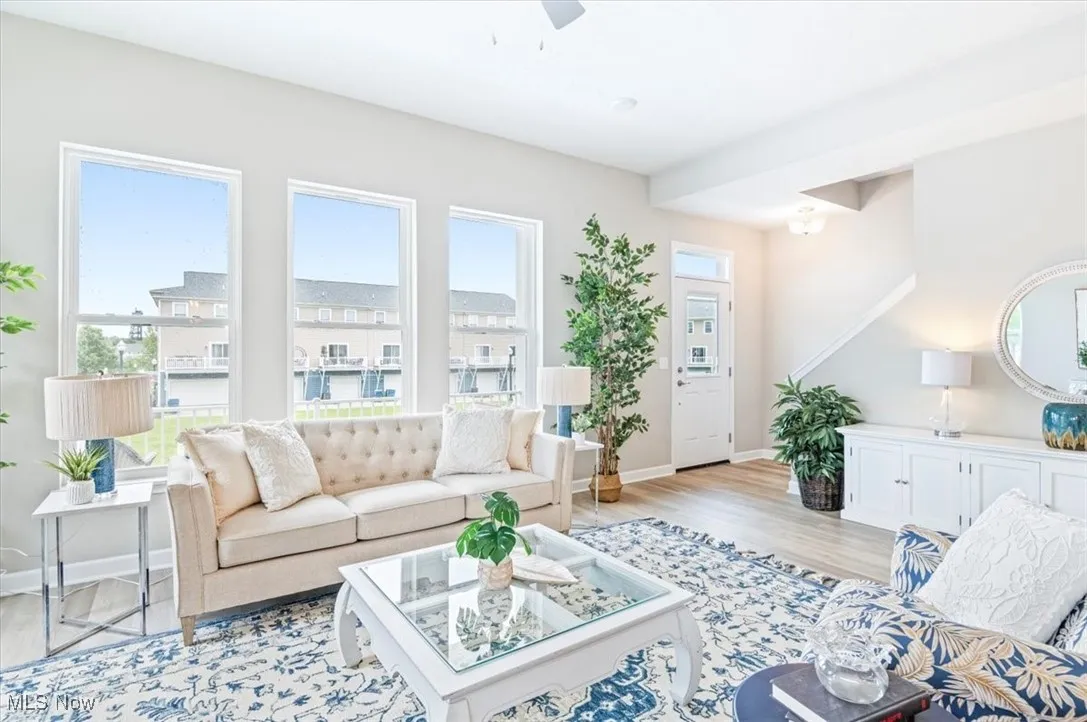Living room featuring baseboards, light wood-style flooring, and ceiling fan