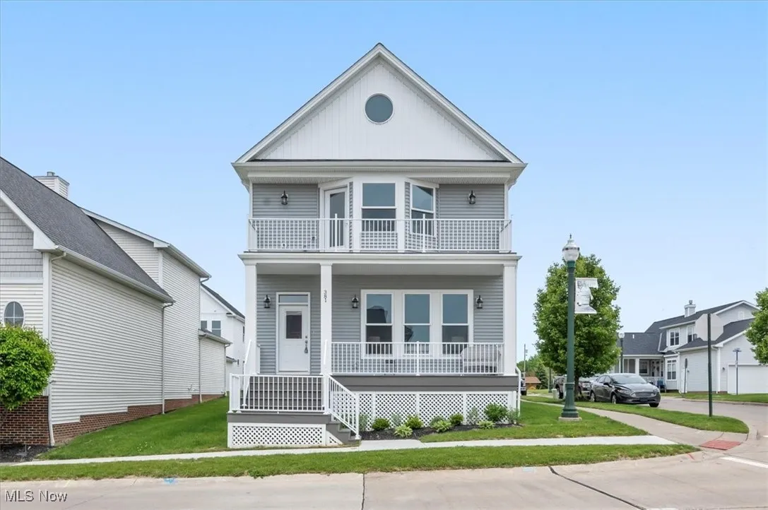 View of front of house with a balcony, covered porch, and a front lawn