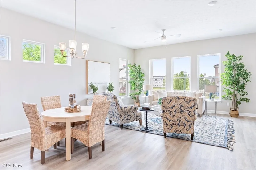 Dining area with light wood-type flooring, a chandelier, baseboards, ceiling fan, and recessed lighting