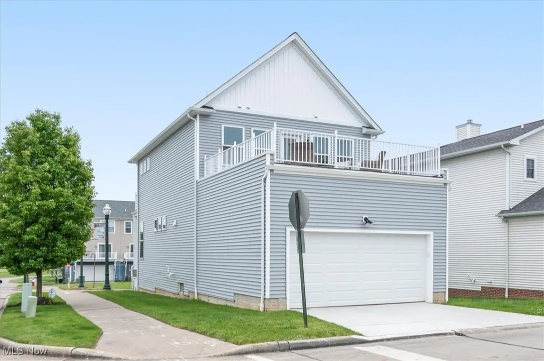 View of front of property featuring a balcony, an attached garage, driveway, and board and batten siding
