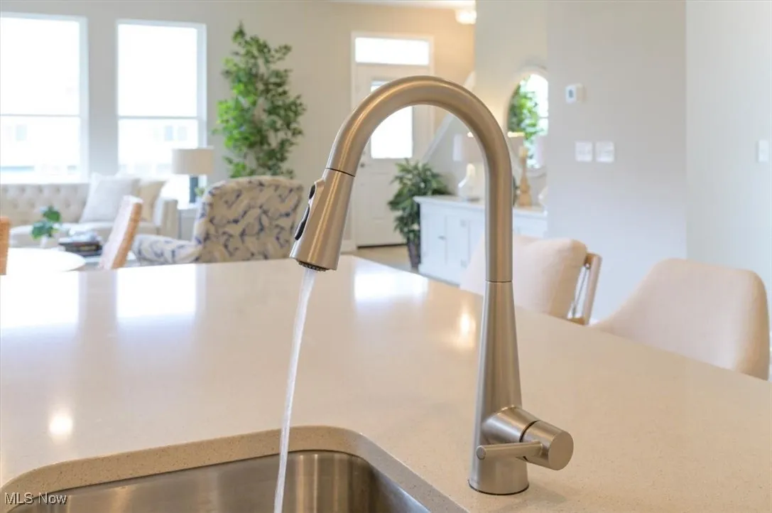 Kitchen view of a sink and light countertops