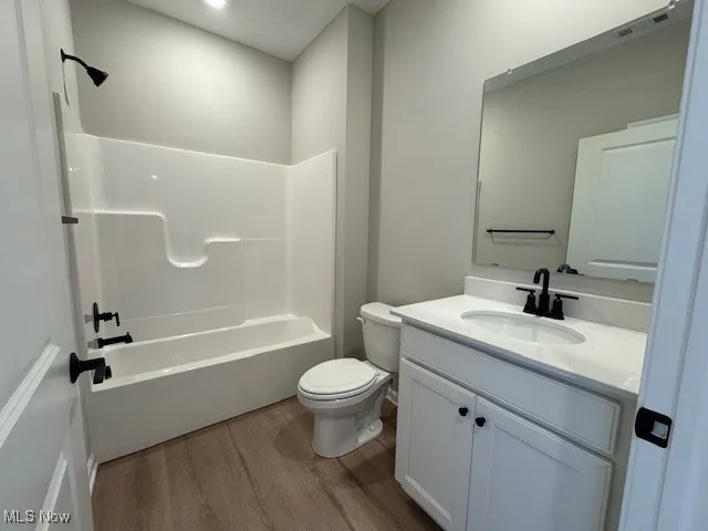 Full bath with vanity, wood finished floors, and  shower combination